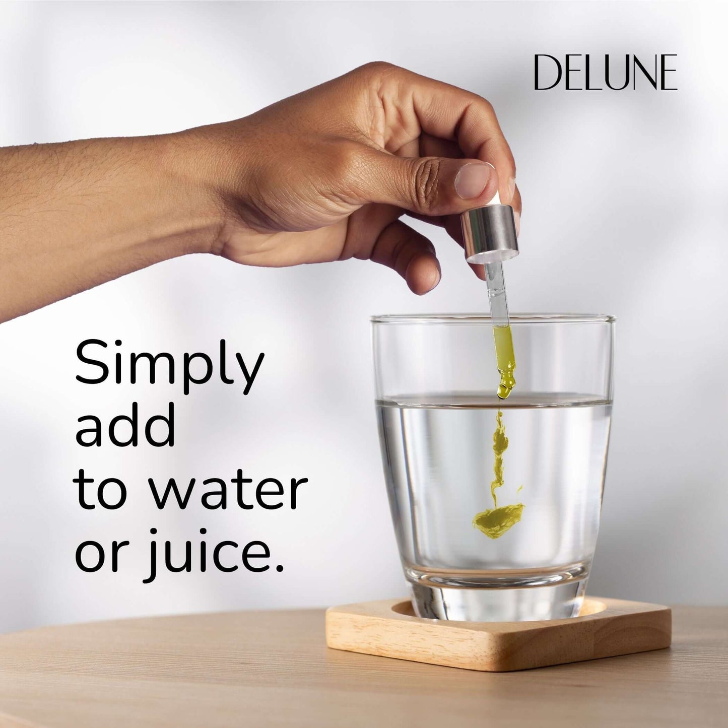 Hand adding herbal tincture to water with dropper, showcasing easy use of Organic Elderberry Herbal Tincture for immune boosting.