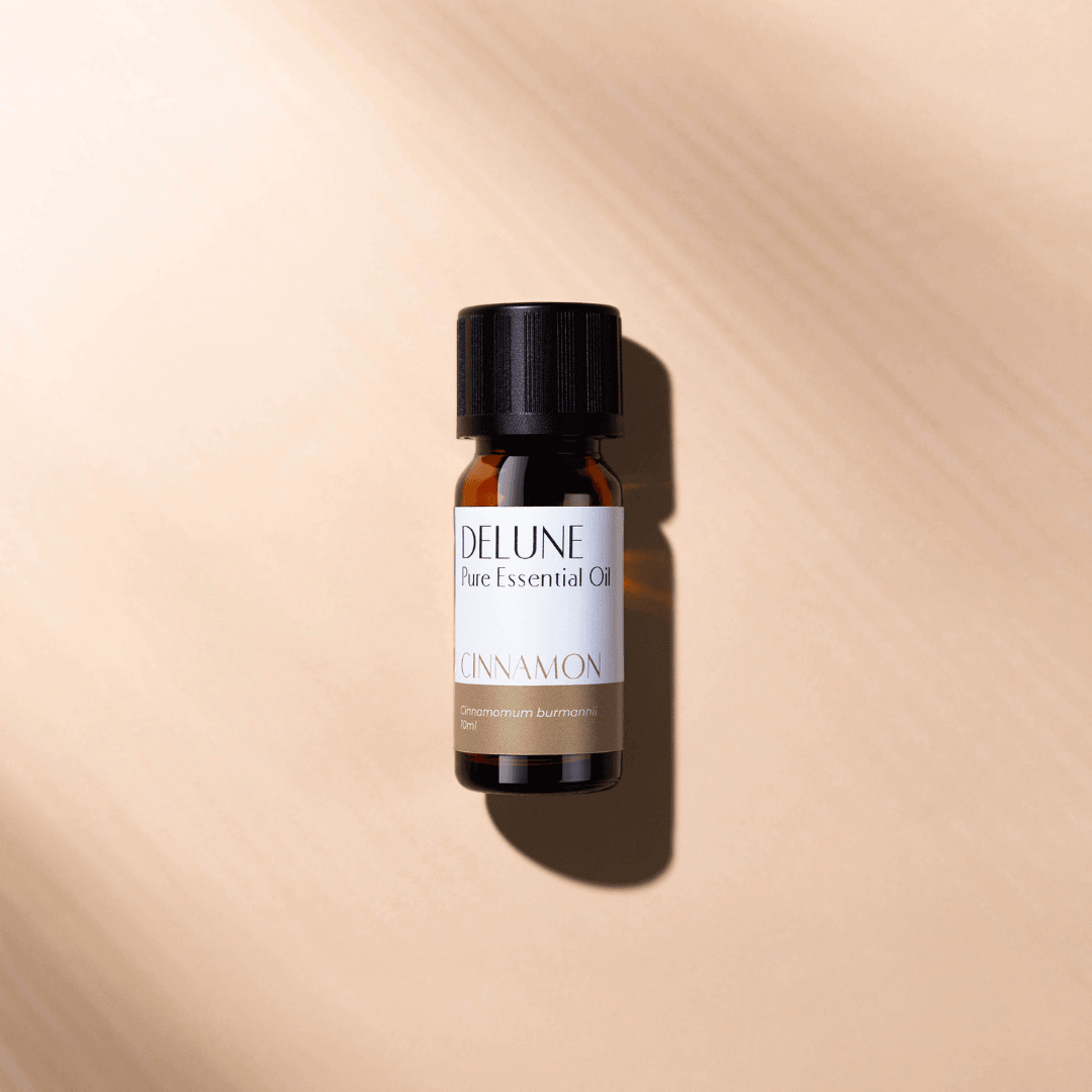 Cinnamon Pure Essential Oil bottle against a warm background, highlighting its aromatic, comforting, and cozy fragrance allure.