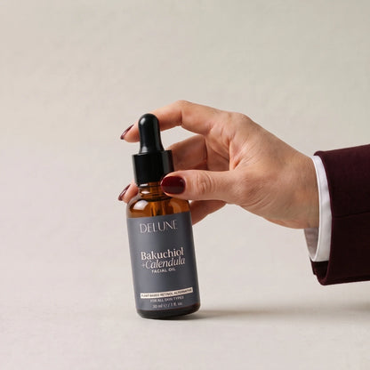 Hand picking up Delune Bakuchiol + Calendula Facial Oil