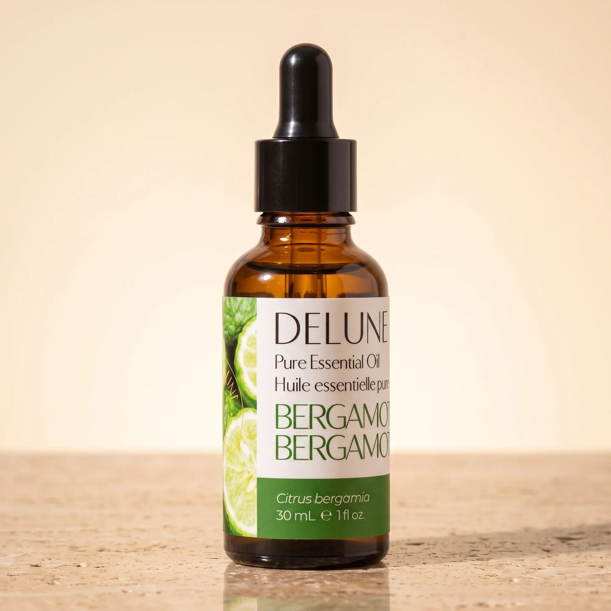 Delune Bergamot Pure Essential Oil, 30ml amber glass dropper bottle on warm travertine stone