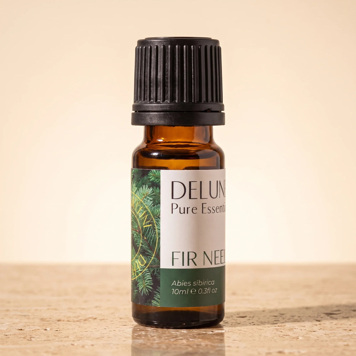 Delune Fir Needle Pure Essential Oil, 10ml amber glass bottle on warm travertine stone