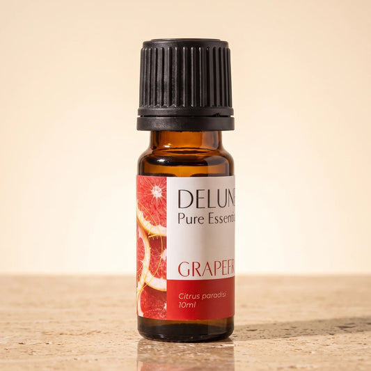 Delune Grapefruit (Pink) Pure Essential Oil, 10ml amber glass bottle on warm travertine stone