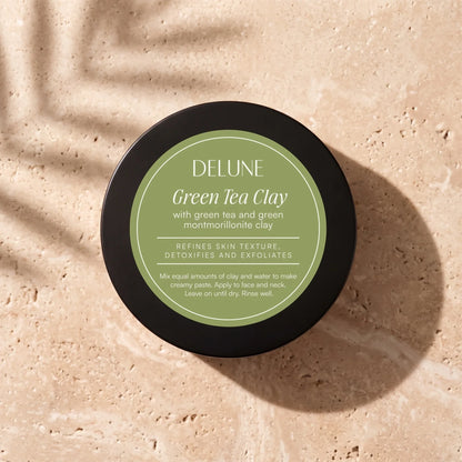 Delune Green Tea Clay Mask jar from above on warm travertine in soft window light