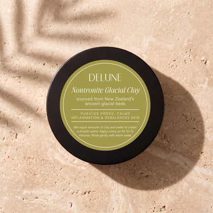 Delune Nontronite Glacial Clay Mask jar from above on warm travertine in soft window light