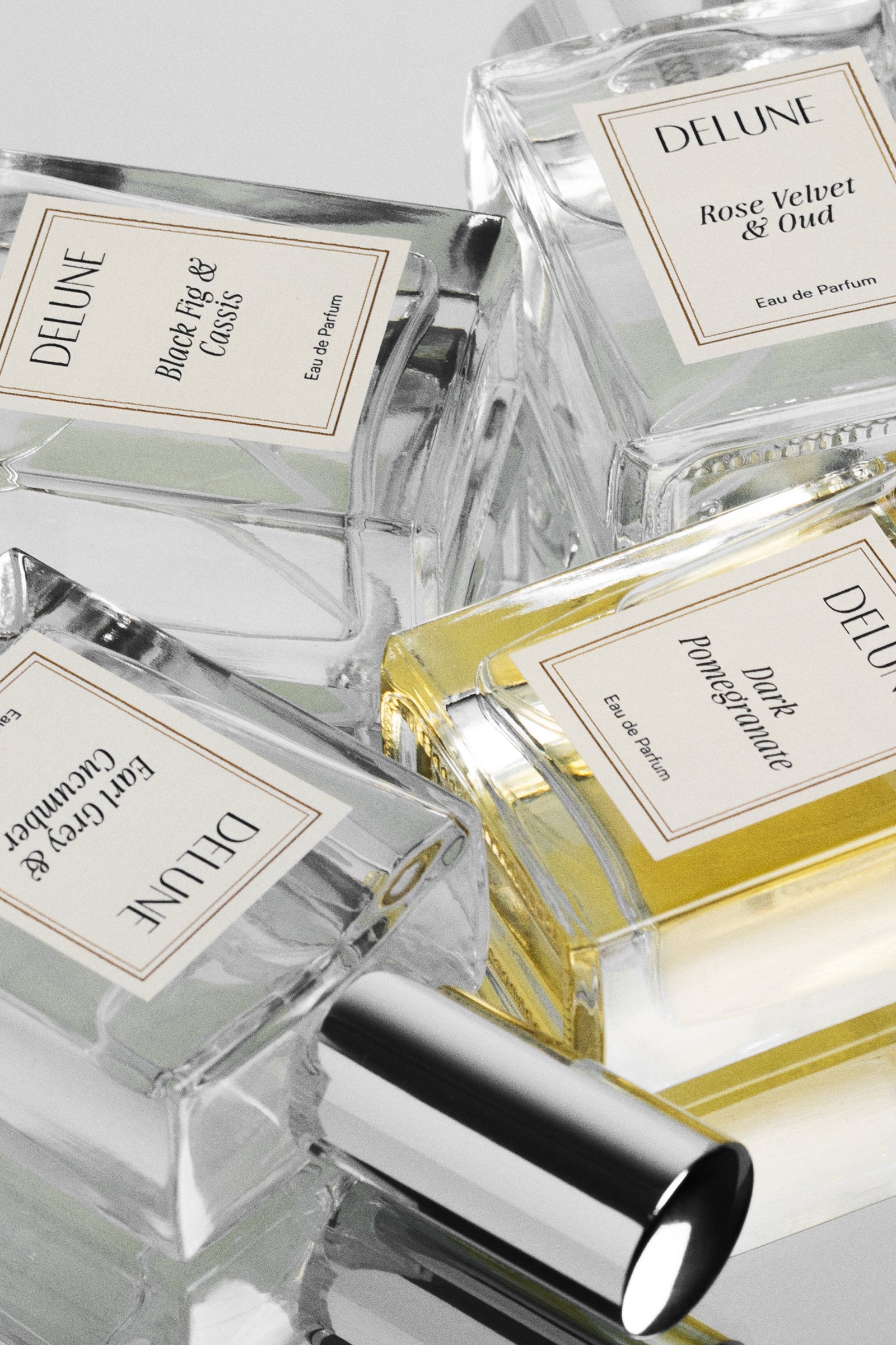Collection of Delune perfume bottles with various scents on a light gray background