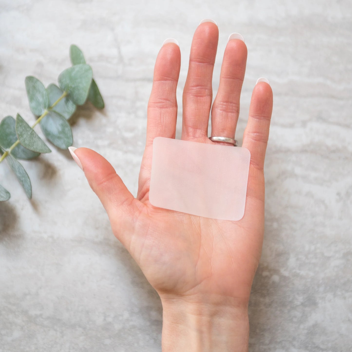 Hand holding a single hand soap sheet; compact, eco-friendly, and perfect for travel and sustainable, chemical-free cleanliness.
