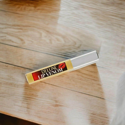 Lip Venom Plumping Glossy Balm on wooden surface, ultimate hydrating lip care for smooth, hydrated lips.